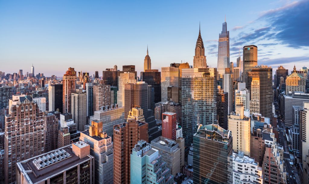 This high angle sunrise view from UN Plaza on the east side of Manhattan looks southwest over the Kips Bay neighborhood toward the Empire State Building, the Chrysler Building, and One Vanderbilt with Lower Manhattan and One World Trade Center in the distance.